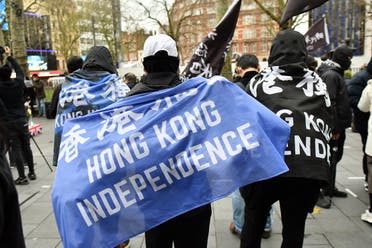 Protesters gather with banners at an event organized by Justitia Hong Kong to mourn the loss of Hong Kong’s political freedoms, in Leicester Square, central London on December 12, 2020. (Justin Tallis/AFP)