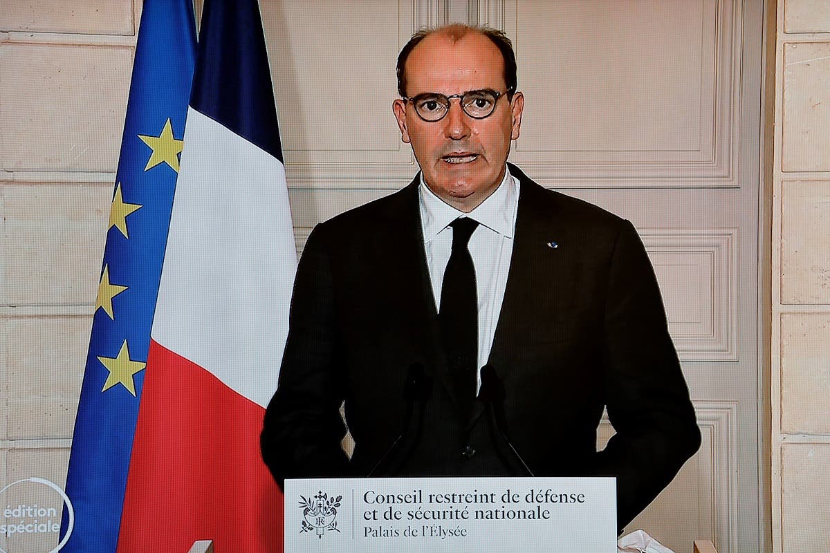 French PM Jean Castex is seen on a TV screen in Paris as he delivers an address following a Sanitary Defense Council on Jan. 29, 2021. (AFP)