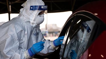 A military medical worker collects on January 12, 2021 a swab sample from a person going through a drive-in swab testing center for COVID-19 set up by the army on the parking lot of the Juventus stadium in Turin, Italy. (Marco Bertorello/AFP)