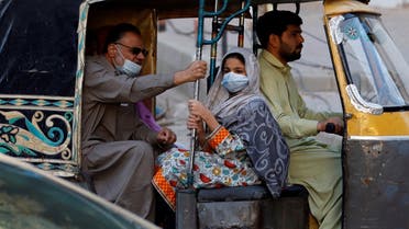 People with masks against COVID-19 travel by rikshaw (tok tok) in Karachi, Pakistan January 25, 2021. (Reuters/Akhtar Soomro)