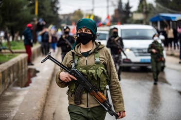 A member of the Kurdish internal security services known as Asayish stands guard as Syrian Kurds demonstrate in the northeastern city of Qamishli on January 20, 2021 to protest the Turkish occupation of the Kurdish Syrian city of Afrin, marking three years since Turkey and its Syrian proxies took control of the region in the northern Aleppo province. (Delil Souleiman/AFP)