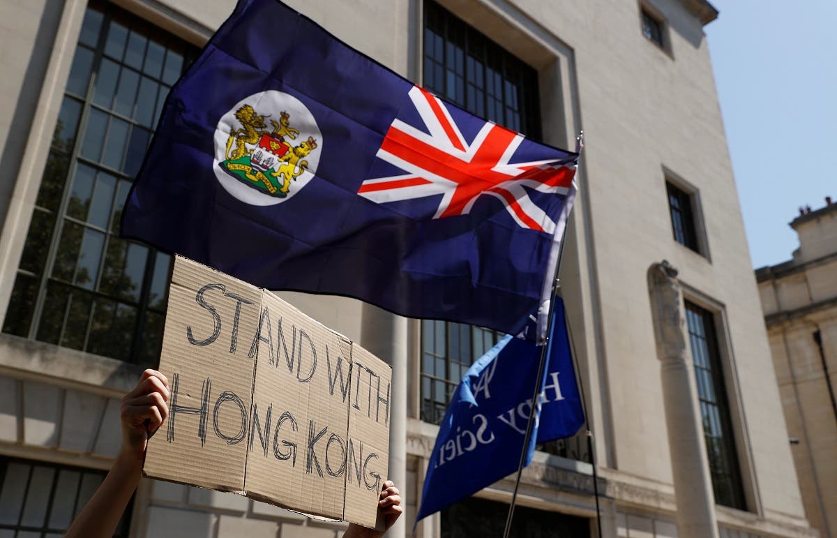 A flag of Hong Kong is waved in front of a placard during a protest against Hong Kong's deteriorating freedoms outside China's embassy, in London, Britain, July 31, 2020. (Reuter/John Sibley)