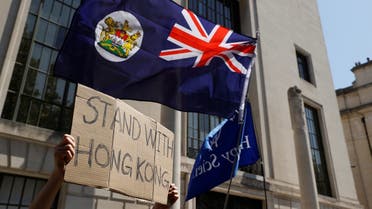 A flag of Hong Kong is waved in front of a placard during a protest against Hong Kong's deteriorating freedoms outside China's embassy, in London, Britain, July 31, 2020. (Reuter/John Sibley)
