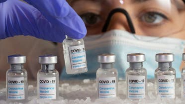 Woman holds a vial labelled COVID-19 Coronavirus Vaccine over dry ice in this illustration taken, December 5, 2020. (Reuters)