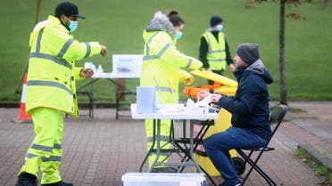 A health worker talks with a man taking a swab test in Goldsworth Park, as the South African variant of the novel coronavirus is reported in parts of Surrey, in Woking, Britain, on February 1, 2021. (Reuters)