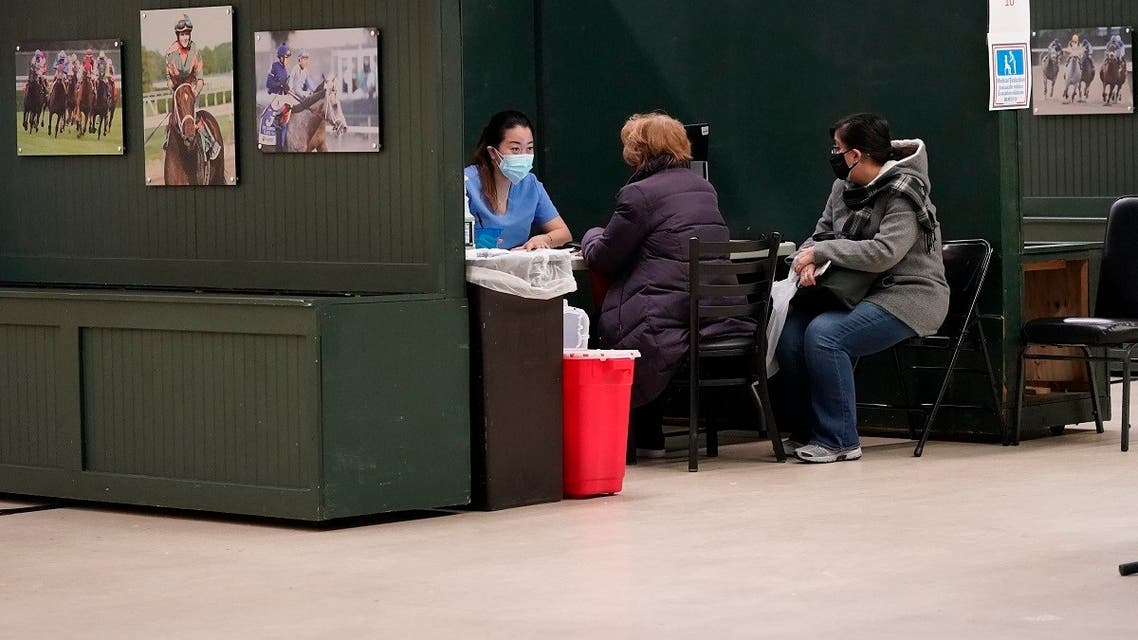 A health care worker, left, prepares to give a coronavirus vaccine to a patient at a COVID-19 vaccination site at the Aqueduct Race Track, Jan. 21, 2021, in the Queens borough of New York. (AP/Mary Altaffer)