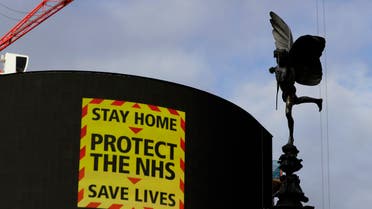 The Eros statue stands in Piccadilly Circus above an NHS sign on the advertising boards in London. (AP)