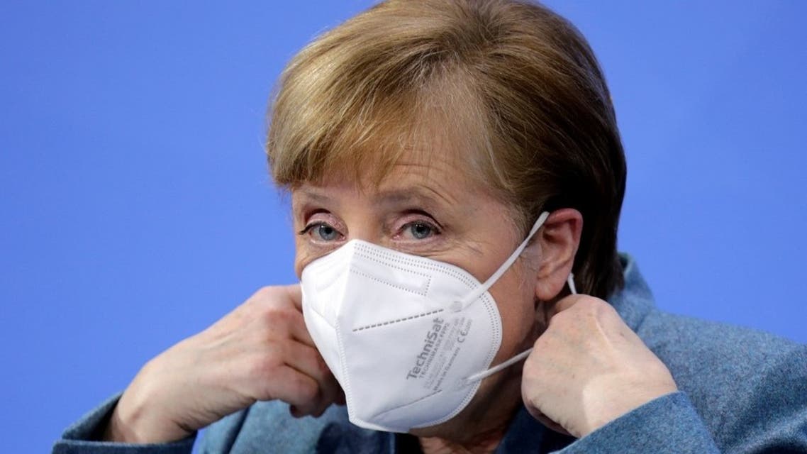 German Chancellor Angela Merkel removes her face mask ahead of a news conference in Berlin, on February 1, 2021. (AFP)