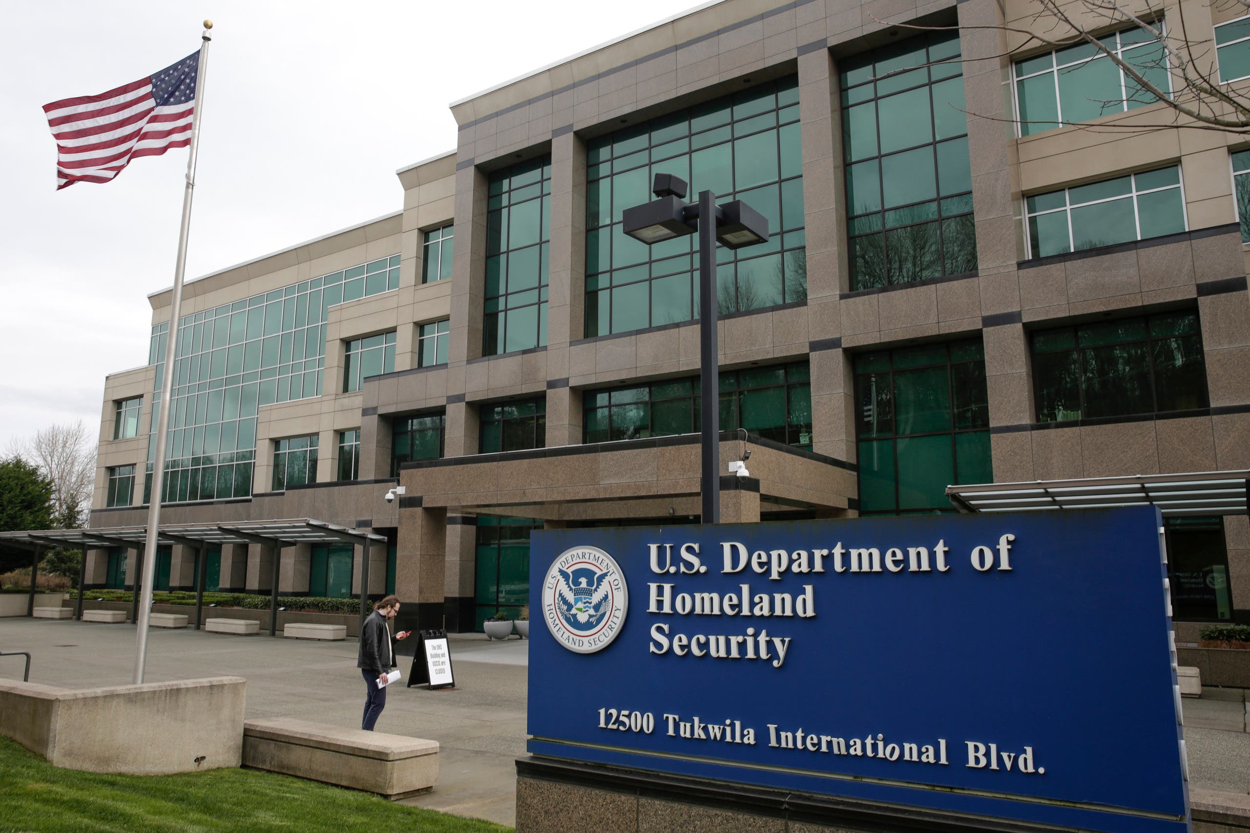 A man stands outside the US Department of Homeland Security (DHS) building and US Citizenship and Immigration Services (USCIS). (AFP)