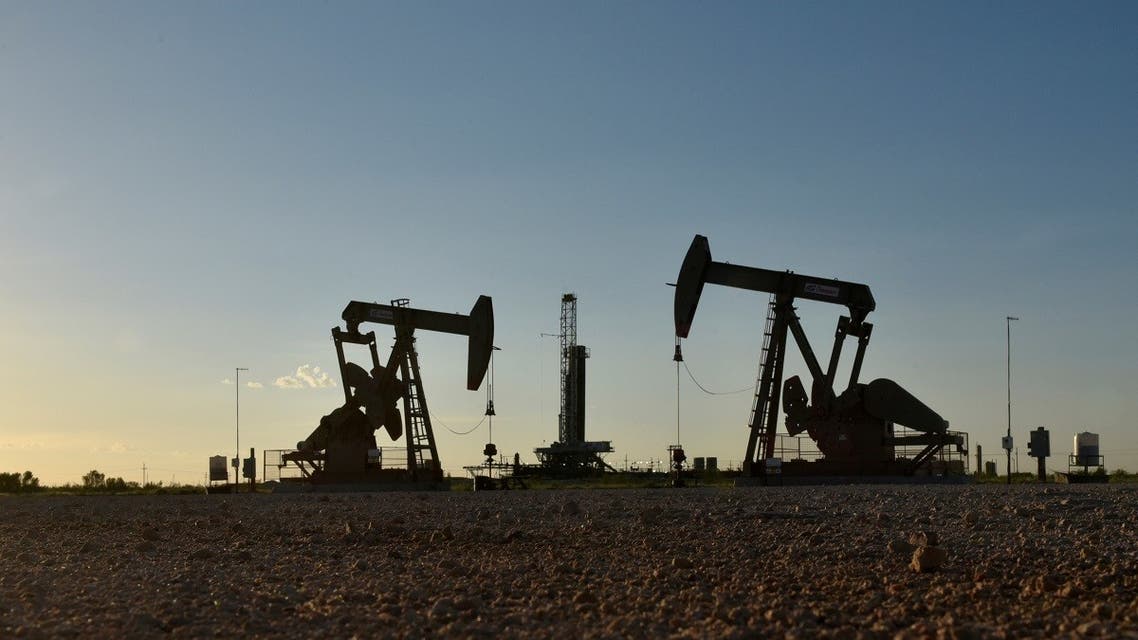 Pump jacks operate in front of a drilling rig in an oil field in Midland, Texas, US. (Reuters)