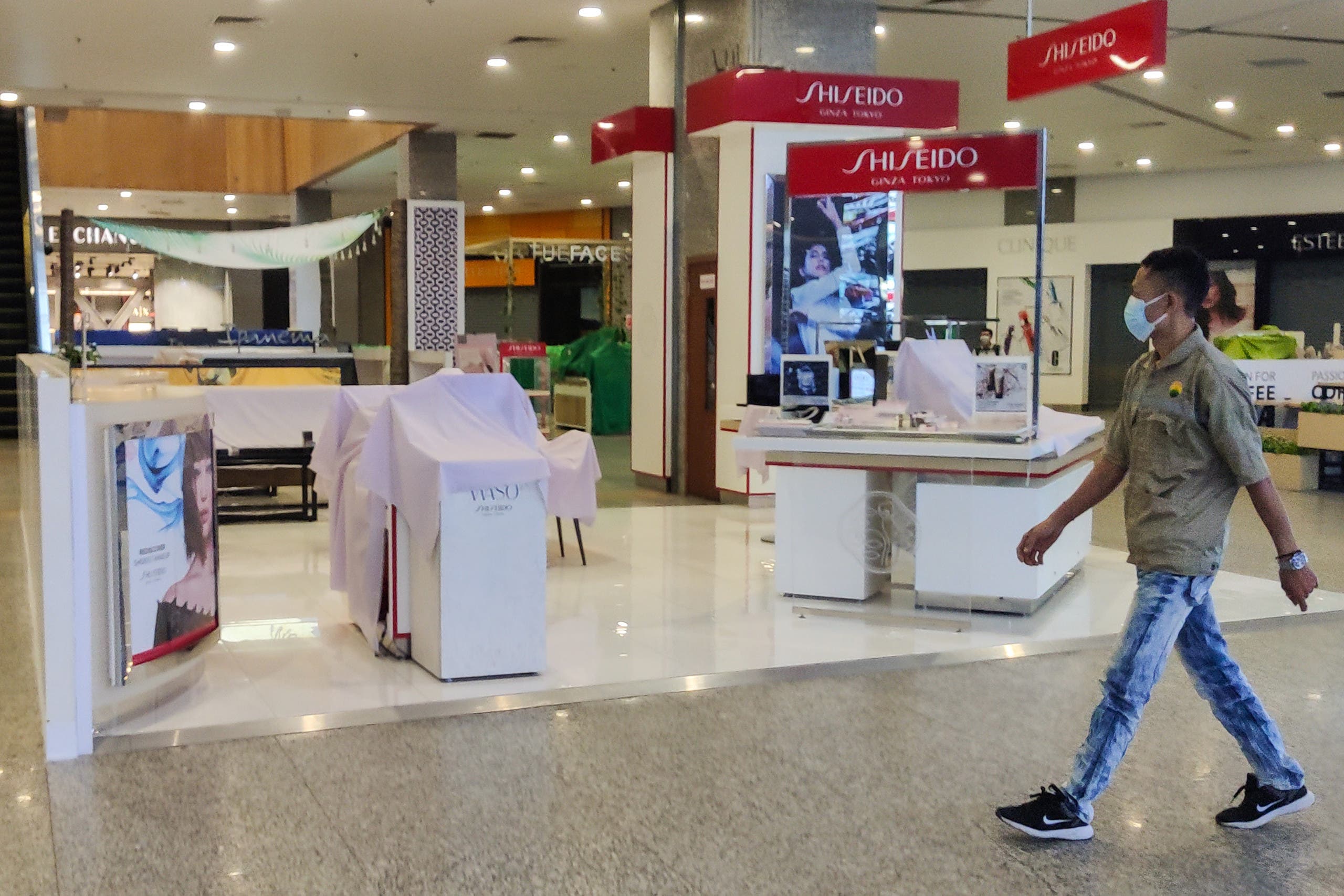 A man walks past a closed cosmetics booth in a shopping center in Yangon on February 1, 2021, after Myanmar's military seized power in a bloodless coup on Monday, detaining democratically elected leader Aung San Suu Kyi as it imposed a one-year state of emergency. (AFP)