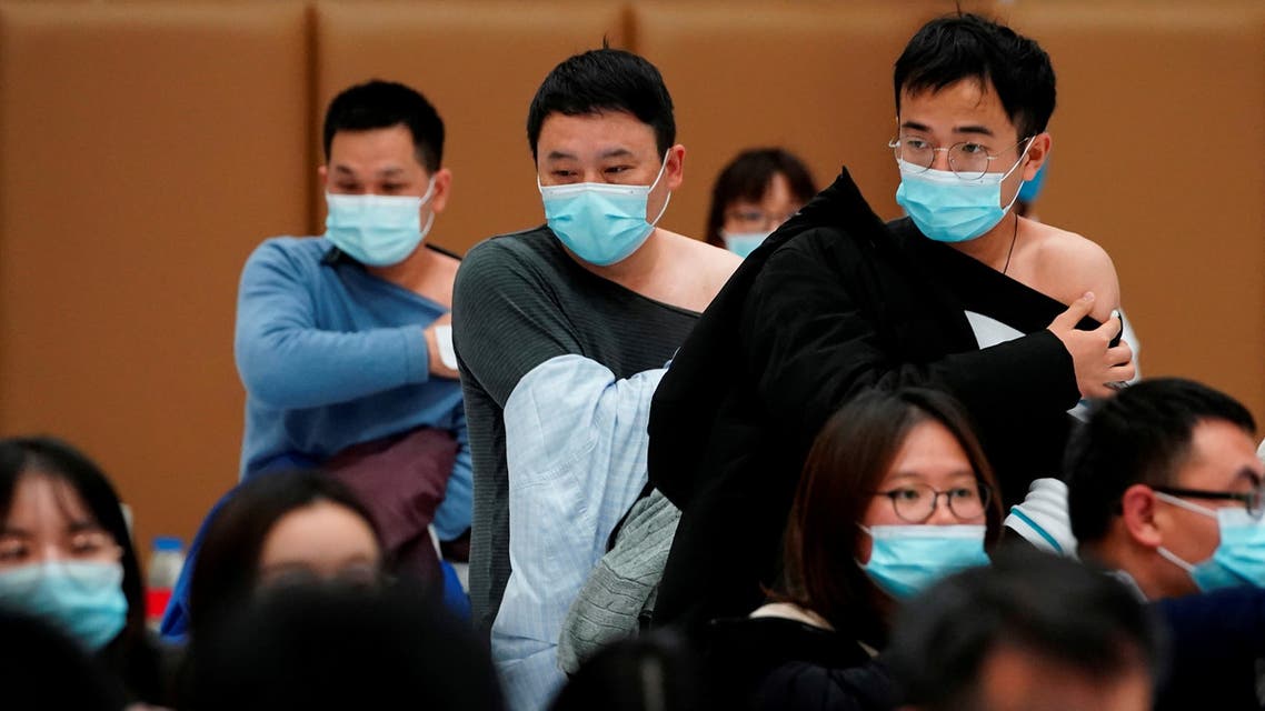 People stand at a vaccination site after receiving a dose of a coronavirus disease (COVID-19) vaccine, in Shanghai. (Reuters)