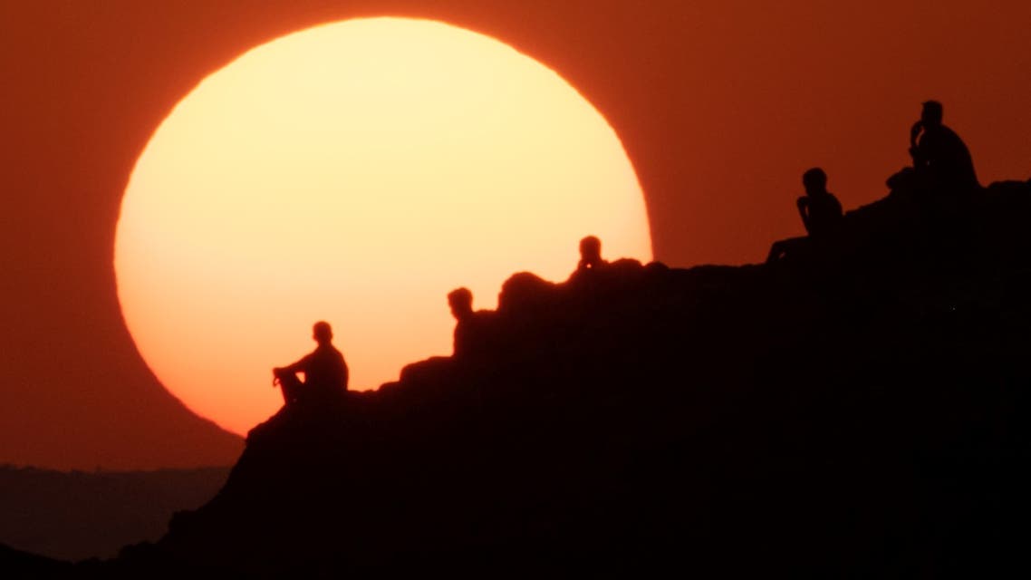 Ethiopian refugees who fled the Ethiopia's Tigray conflict watch the sunset on a hill at the Um Raquba refugee camp in Sudan's eastern Gedaref state on December 12, 2020.