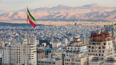 Waving Iran flag above skyline of Tehran at sunset. (iStock)