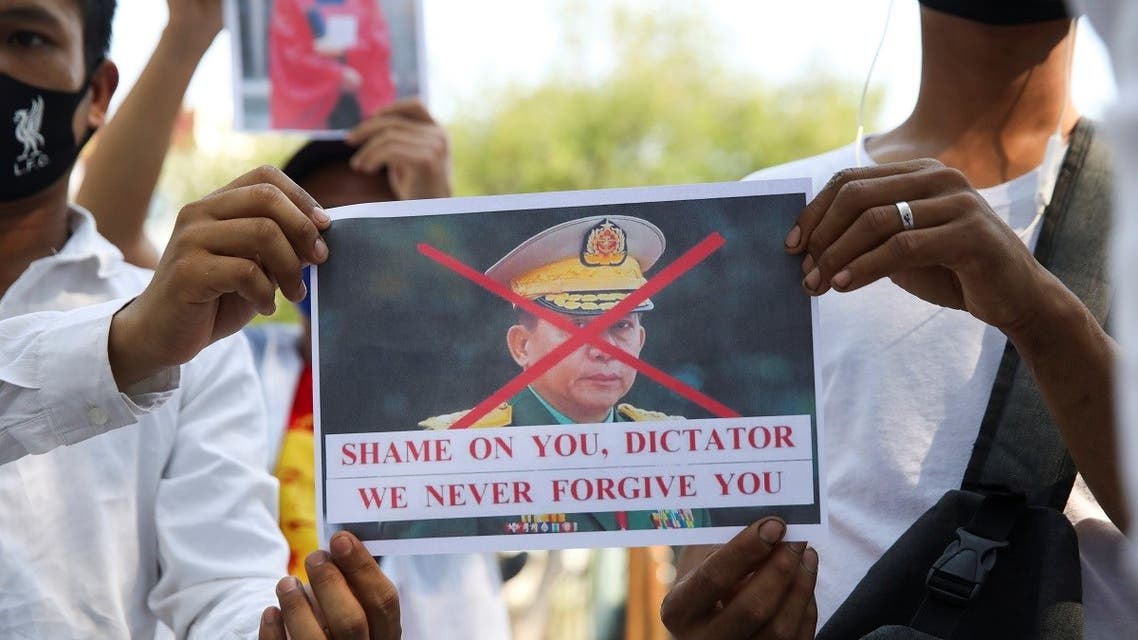 Myanmar citizens hold a picture of Myanmar's army chief Min Aung Hlaing with his face crossed out after the military seized power in a coup in Myanmar, outside United Nations venue in Bangkok, Thailand February 3, 2021. (Reuters)