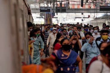 People covering their faces with protective masks disembark a suburban train after authorities resumed the train services for all commuters after it was shut down to prevent the spread of the coronavirus disease (COVID-19), at a railway station in Mumbai, India, February 1, 2021. REUTERS/Hemanshi Kamani