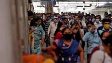 People covering their faces with protective masks disembark a suburban train after authorities resumed the train services for all commuters after it was shut down to prevent the spread of the coronavirus disease (COVID-19), at a railway station in Mumbai, India, February 1, 2021. REUTERS/Hemanshi Kamani