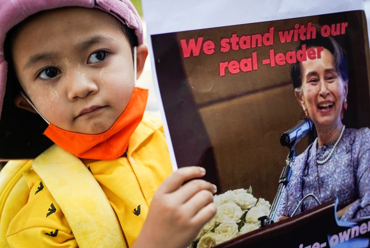 A child holds a picture of leader Aung San Suu Kyi outside the United Nations venue after the military seized power in a coup in Myanmar, in Bangkok, Thailand, on February 3, 2021. (Reuters)