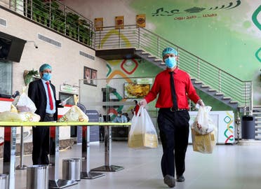A food delivery worker wearing protective face mask and gloves, following the outbreak of the coronavirus disease (COVID-19), carries Ramadan meal orders at a restaurant in Riyadh, Saudi Arabia April 26, 2020. (Reuters)