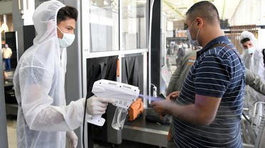 A health worker sprays sanitizer on a passenger at Damascus International Airport on its re-opening day for regular international commercial traffic after months of closure following the coronavirus outbreak on October 1, 2020, Syria. (Reuters)