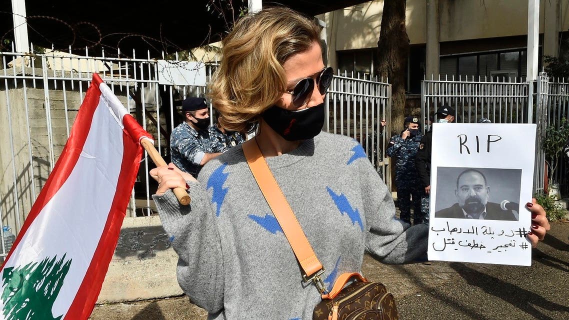 A protesters holds a picture of slain prominent Lebanese activist and intellectual Lokman Slim, during a rally in front of the Justice Palace in Beirut, on Feb. 4, 2021. (AFP)