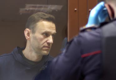 Kremlin critic Alexei Navalny, who is accused of slandering a Russian World War Two veteran, stands inside a defendant dock before a court hearing in Moscow, Russia, on February 5, 2021. (Reuters)