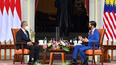 In this photo released by Indonesian Presidential Palace, Malaysian Prime Minister Muhyiddin Yassin, left, talks with Indonesian President Joko Widodo during their meeting at Merdeka Palace in Jakarta, Indonesia, Friday, Feb. 5, 2021. (AP)
