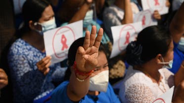 A  university teacher holds up a three-finger salute during a protest against the military coup at Dagon University in Yangon on February 5, 2021. (AFP)