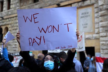 A student from the American University of Beirut (AUB) holds up a placard during a protest against the adjustment of the dollar rate for new tuition fees, in Beirut, Lebanon, Tuesday, Dec. 29, 2020. (File photo: AP)