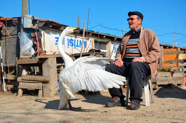 Recep Mirzan, a 63-year-old retired postman and Garip share a moment in his farmhouse outside Karaagac, in Turkey's western Edirne province, bordering Greece, Saturday, Feb. 6, 2021. (AP/Ergin Yildiz)
