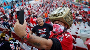 A fan wearing a protective face mask due to the coronavirus disease (COVID-19) takes a selfie inside the stadium before the game. (Reuters)