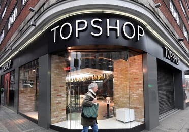 A man walks past a closed branch of Topshop, after the British online fashion retailer ASOS said it has bought the brand amongst others from the collapsed Arcadia group, Londonon February 1, 2021. (Reuters)