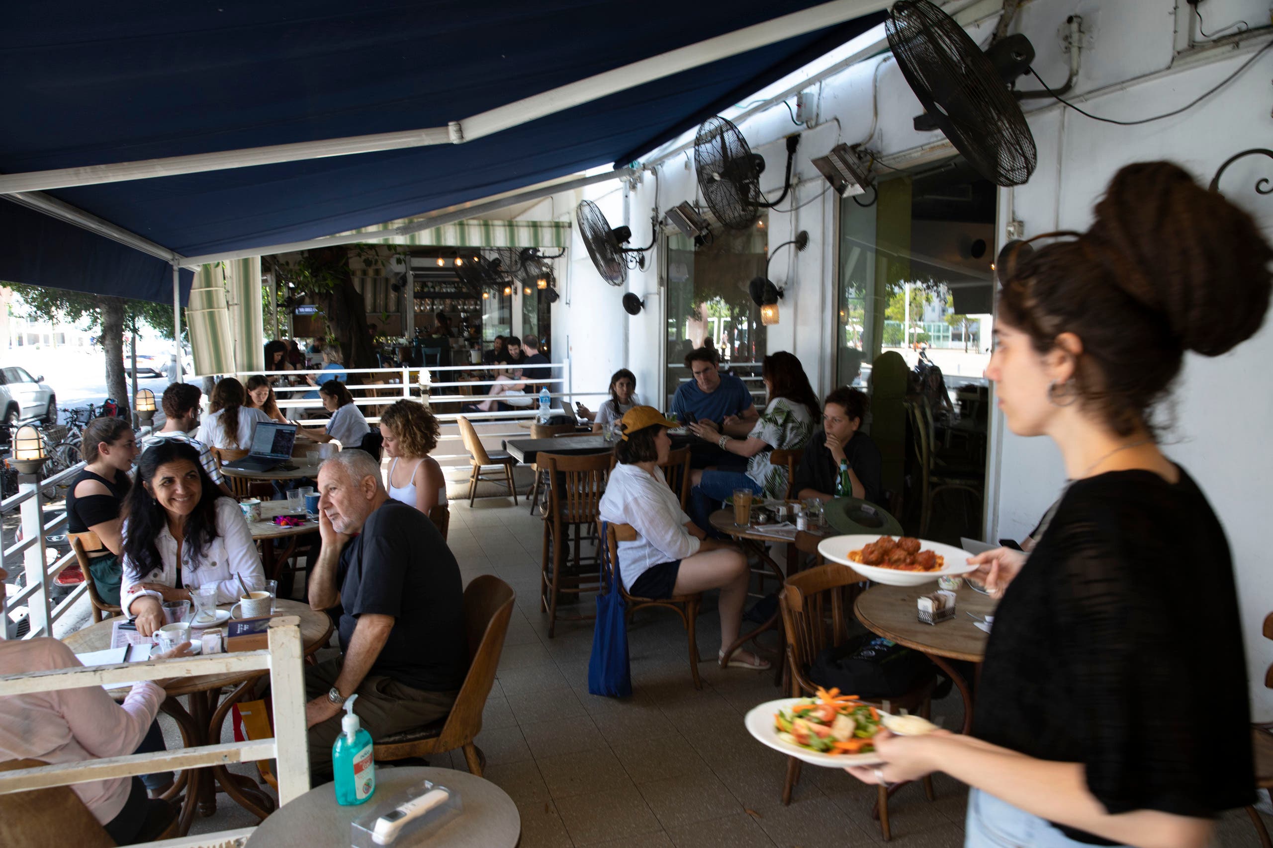 A waitress serves food at a restaurant in Tel Aviv, Israel, Wednesday, May 27, 2020. (File photo: AP)