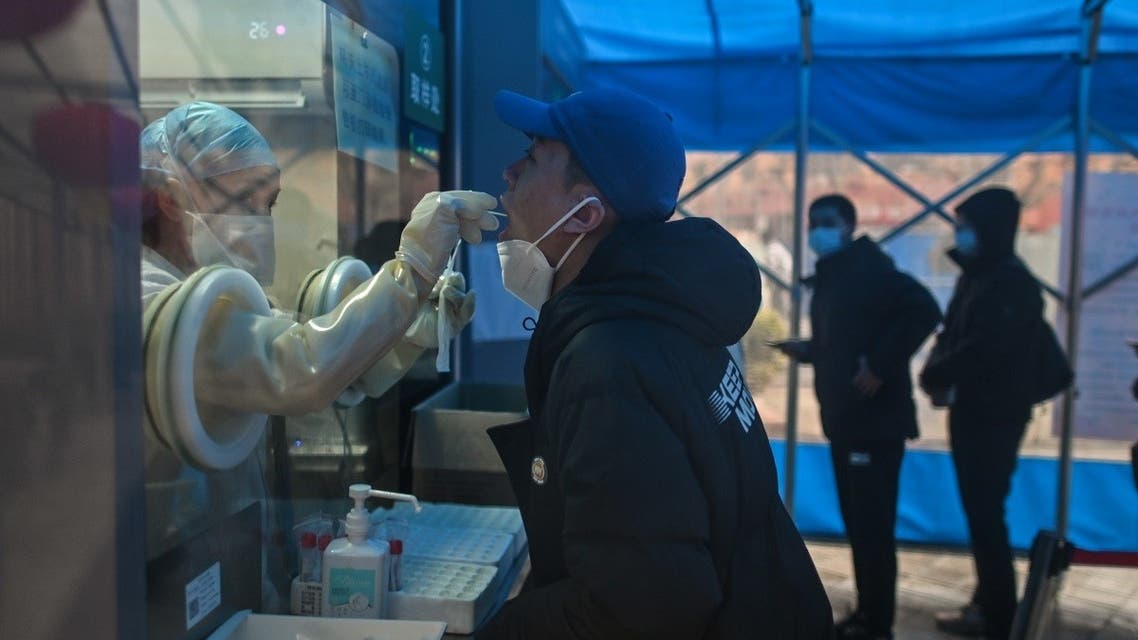 A health worker takes a swab sample from a man to test for the COVID-19 coronavirus at a hospital in Wuhan. (AFP)