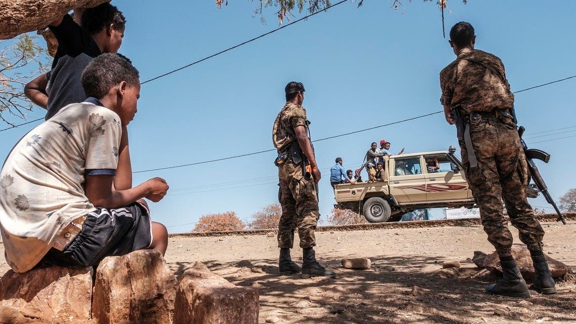 Ethiopian Army soldiers stand as a pick-up truck with militia men passes by at Mai Aini Refugee camp, in Ethiopia, on Jan. 30, 2021. (AFP)