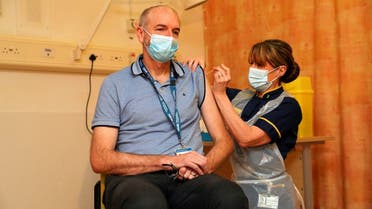 Professor Andrew Pollard, Director of the Oxford Vaccine Group (OVG), and a professor of Paediatric Infection and Immunity receives the Oxford University/AstraZeneca COVID-19 vaccine from nurse Sam Foster at the Churchill Hospital in Oxford, Britain, on January 4, 2021. (Reuters)