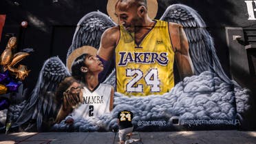 Adam Dergazarian, bottom center, pays his respect for Kobe Bryant and his daughter, Gianna, in front of a mural painted by artist Louie Sloe Palsino, Tuesday, Jan. 26, 2021, in Los Angeles. (AP)
