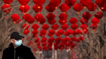 A man wearing a face mask to protect against the spread of the coronavirus walks past rows of decorative lanterns at Ditan Park in Beijing, Tuesday, Feb. 9, 2021. (AP)