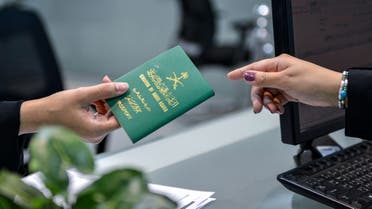 A Saudi woman receives her newly-issued passport at the Immigration and Passports Centre in the capital Riyadh on August 29, 2019. (AFP)