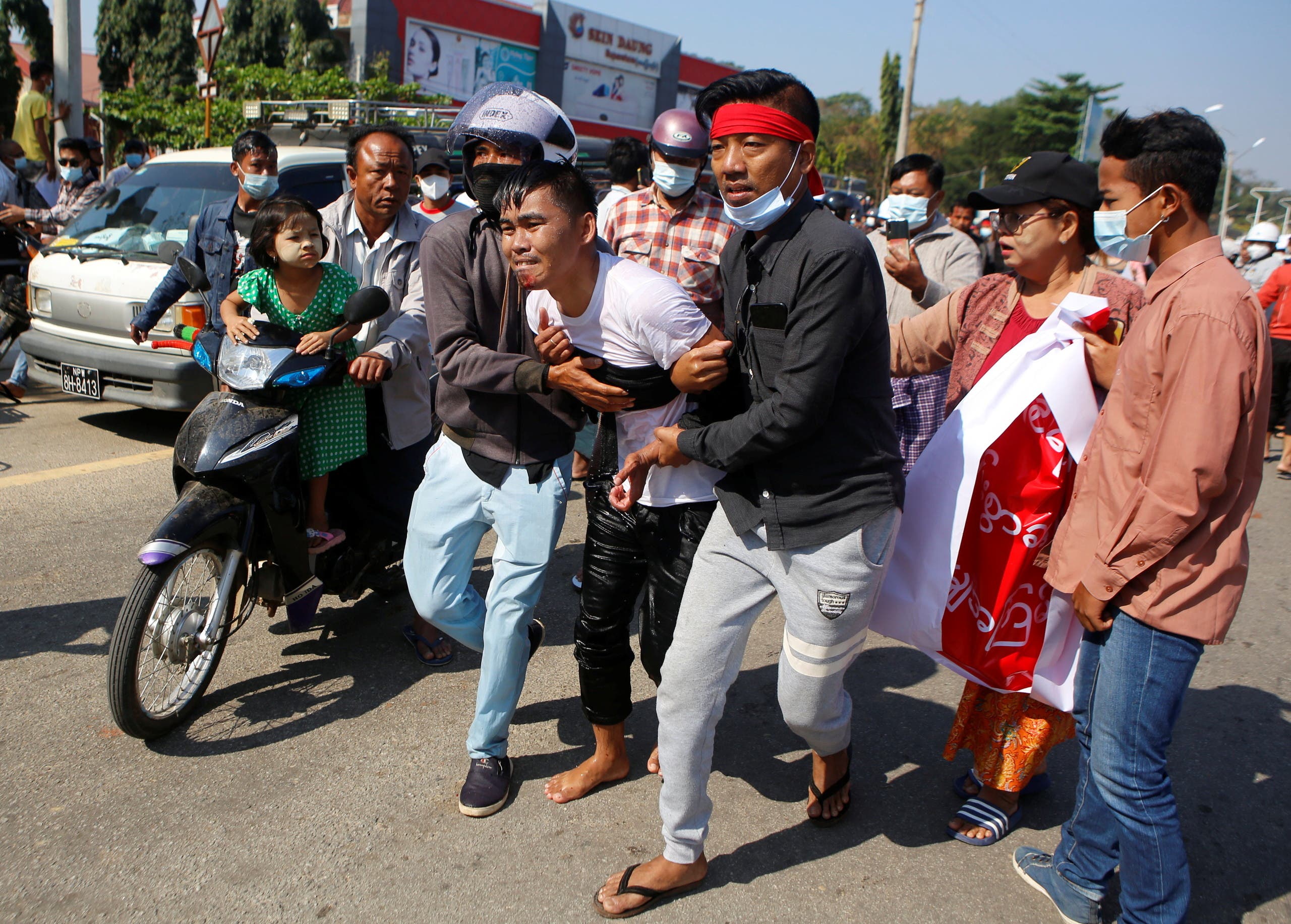 An injured protester is helped by his fellow protesters, at a rally against the military coup and to demand the release of elected leader Aung San Suu Kyi, in Naypyitaw, Myanmar, February 9, 2021. (Reuters)