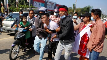 An injured protester is helped by his fellow protesters, at a rally against the military coup and to demand the release of elected leader Aung San Suu Kyi, in Naypyitaw, Myanmar, February 9, 2021. (Reuters)