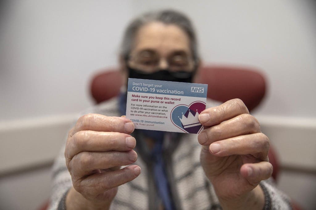 Bernice Wainer, 82, holds up her vaccination card as she receives a dose of the Pfizer-BioNTech Covid-19 vaccine at the Royal Free hospital in London on December 8, 2020 at the start of the UK's biggest ever vaccination programme. (File photo: AFP)