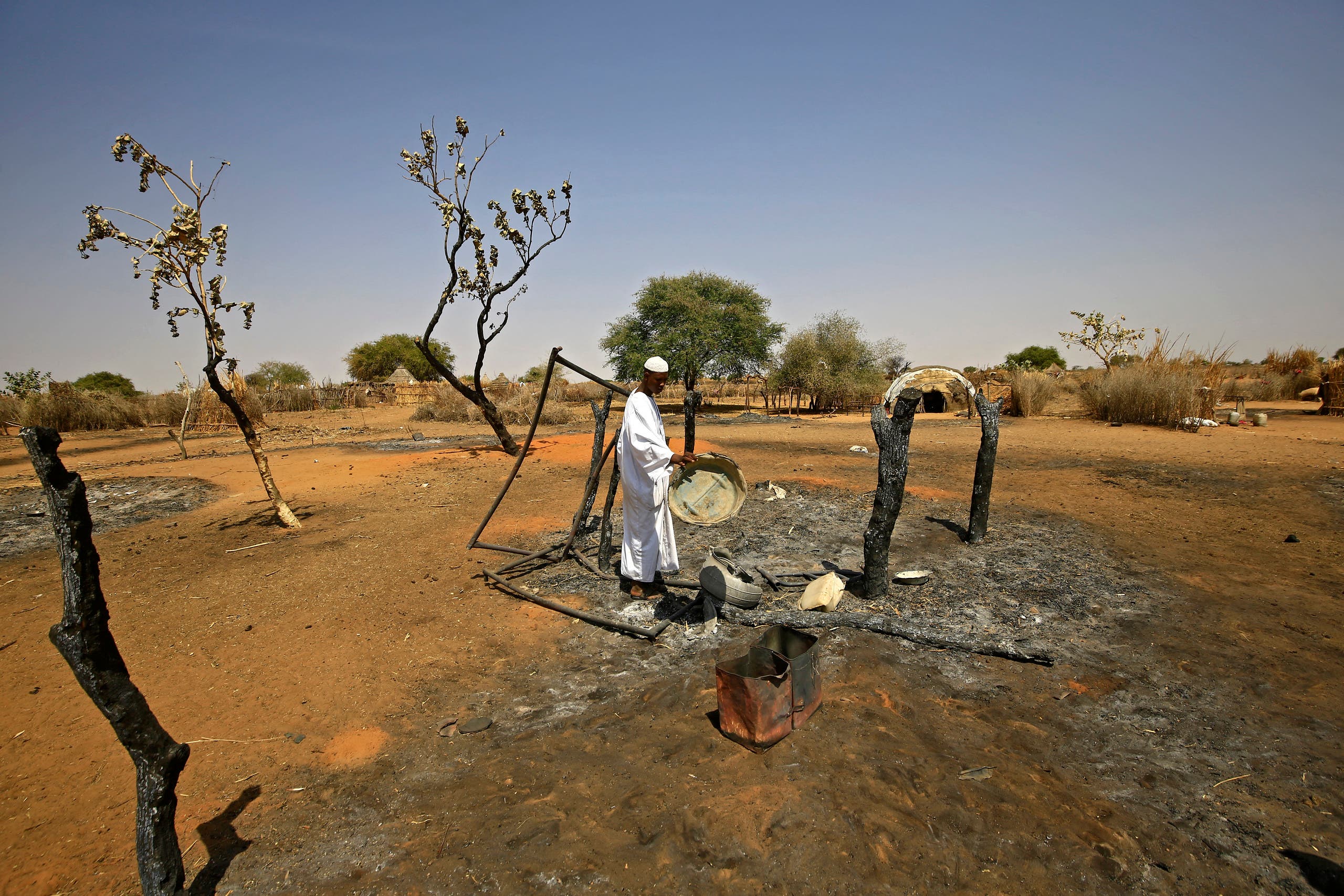 A Sudanese man checks the aftermath of violence in the village of Twail Saadoun, 85 kilometres south of Nyala town, the capital of South Darfur, on February 2, 2021. (AFP)