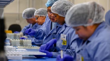 Employees work on the production line of a coronavirus home test unit in Brisbane. (AFP)
