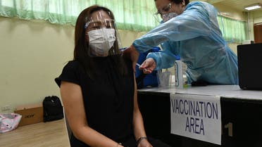 A city hall employee (L) takes part in a vaccination simulation in Manila. (AFP)