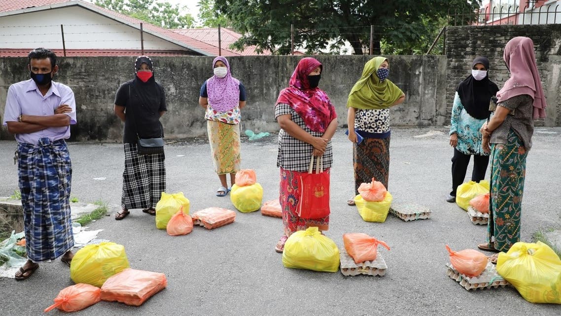 Rohingya refugees wearing protective masks waiting to receive goods from volunteers, during the movement control order due to the outbreak of the coronavirus, in Kuala Lumpur, Malaysia. (Reuters)
