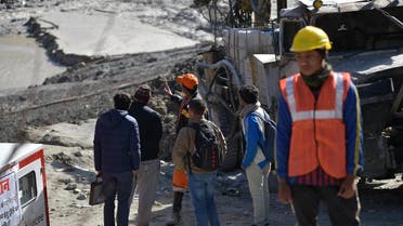 Defence research and development organization (DRDO) scientists talk with an emergency and rescue official (in orange cap) after arriving near Tapovan tunnel, where dozens are still feared to be trapped, during rescue operations in Tapovan of Chamoli district on February 12, 2021 following a flash flood thought to have been caused when a glacier burst on February 7. (AFP)