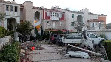 People walk among the debris after a small tornado has struck Cesme, a town on Turkey's Aegean coast, leaving a path of destruction and injuring sixteen people, Friday, Feb. 12, 2021. (AP)