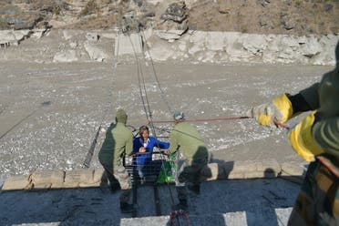 A resident is helped out of a metal basket by Indo-Tibetan Border Police personnel after crossing the Roshiganga river on a temporary zip-line in Chamoli district on February 12, 2021. (AFP)