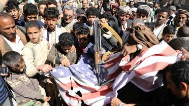 Houthi supporters shatter the US flag during a demonstration outside the US embassy against the decision to designate the Houthis a foreign terrorist organization, in Sanaa, Yemen Jan. 18, 2021. (Reuters)